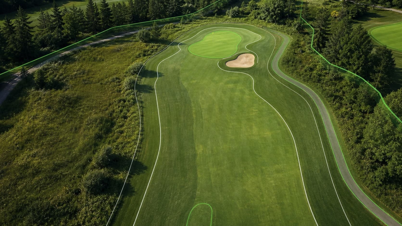 Aerial view of a golf hole with subtle digital boundary lines tracing the fairway, green, and cart path.